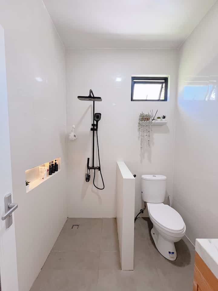 Kamar mandi ini adalah hasil renovasi dari kamar mandi bawaan developer. Semula ukurannya lebih kecil, kami perlebar menjadi 1.8 x 1.8m. Material yang kami pakai untuk lantai yakni granit dengan tekstur matt, dan glossy untuk dinding dengan ukuran 60 x 60cm. Mengapa kami pilih ukuran tersebut agar kamar mandi terkesan lebih luas. Terutama bagian dinding agar lebih clean dan meminimalisir nat pada granit. Untuk sanitary kami pilih warna hitam agar match dengan collor pallete di rumah. Biar terlihat estetik, aku tambahkan WPC di bagian dinding area wastafel dan rak ambalan untuk hiasan bunga. Kamar mandi ini menurutku udah lengkap karena ada wastafel juga kabinetnya untuk penyimpanan barang. Tapi tetap aja ada kesalahan yang sepertinya ini bisa jadi tips buat tetangga. Saran aku kalau buat kamar mandi kering dan basah, lebih baik dibuat dalam bentuk memanjang atau persegi panjang, jangan kotak kayak gini. Karna walaupun pakai sekat dan area kloset tidak basah, cipratan air tetap kena di area wastafel.
#MaterialKamarMandi
#KamarMandi
#InspirasiKamarMandi