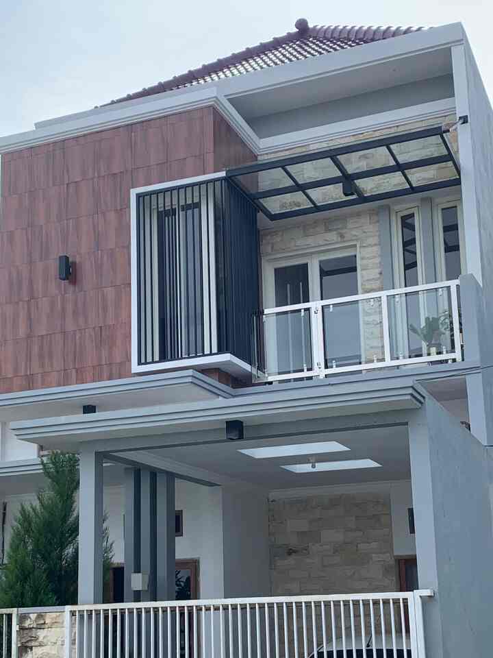 Minimal modern two-story house facade in white and brown tones, featuring a glass balcony and wall sconces with a clean design