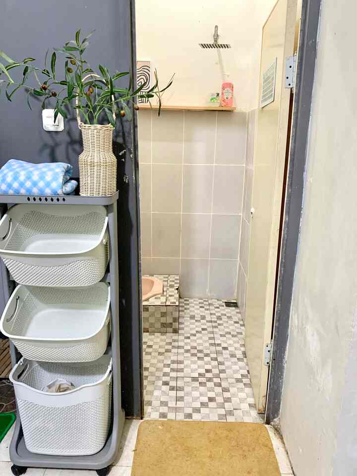 White and natural toned bathroom space, a small long and narrow room featuring storage solutions and artificial olive branch decor