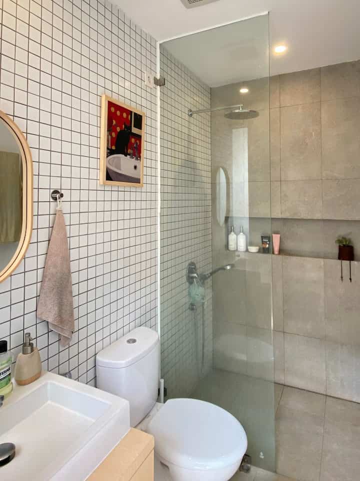 Kami sudah cukup puas dengan desain kamar mandi bawaan dari developer ini sehingga tidak memerlukan banyak perubahan. Kamar mandi ini terbagi menjadi dua area, yaitu area kering dan area basah, yang dipisahkan oleh sekat kaca. Semua materialnya sudah ditentukan dari developer, mulai dari mosaic tiles, granit, hingga peralatan mandi, seperti shower, wastafel, dan toilet duduk. 

Satu hal favorit kami dari kamar mandi ini adalah adanya shower niche yang sangat membantu supaya sabun dan shampo tetap terlihat rapi pada tempatnya. Kami juga memasang hiasan poster dan mini planter agar tidak terkesan monoton dan tetap memiliki sentuhan warna.

#MaterialKamarMandi #KamarMandi #InspirasiKamarMandi