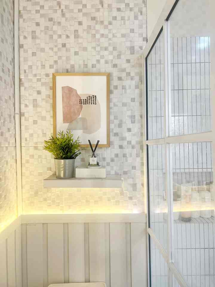 White and gray toned small modern space featuring wall decor and a plant with a clean interior atmosphere
