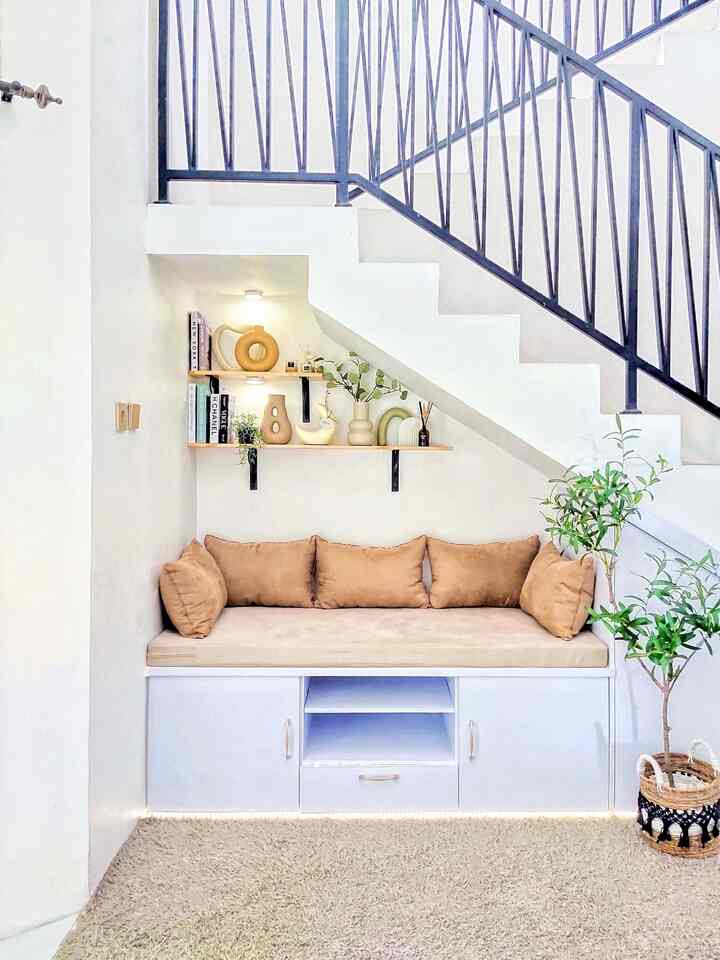 ✨ Lazy Room ✨

Kenapa aku sebut lazy room area ini? Karena di sini memang tempat kami sekeluarga malas-malasan, hehehe.
Tempat kami tidur-tiduran sambil baca buku, scroll medsos, atau ngemil, kadang bisa sampe ketiduran beneran nih di sini 😂
Area ini sebelumnya area paling krisis identitas karena cuma jadi tempat berantakin mainan anak dan barang-barang gak terpakai, akhirnya aku ubah jadi lemari dan bench untuk bersantai.
Letaknya menyatu dengan living room, jadi bench ini juga sebagai sofa tambahan saat sedang banyak tamu di rumah.
Untuk lemari kayunya aku custom di tukang kayu dekat rumah, dengan material kayu jati belanda lapis hpl untuk hemat budget, harganya sekitar 3,6 jutaan.
Bagian bench atau sofanya aku pakai busa yang agak keras supaya dia gak gampang kempes, itu juga custom di e-commers dengan covernya, sedangkan bantalnya aku beli di toko lain lagi.
Untuk bagian ambalan, seperti biasa aku menggunakan material kayu jati belanda vernish natural dan siku besi hitam meliuk, supaya seragam dengan ambalan lain di rumah ini.
Karena rumahku tidak terlalu luas, aku memang selalu memfungsikan tembok sebagai area menaruh barang dan pajangan karna tidak memungkinkan menggunakan lemari lain lagi, takut rumahnya terasa kepenuhan.
Sentuhan terakhir tinggal memberikan lampu LED dan lampu-lampu lainnya untuk mengekspos pajangan.
Dengan budget sekitar 5 jutaan akhirnya area living room di bawah tangga ini lebih fungsional ✨

#lazyroom
#livingroom
#rumahminimalis
#homedecorideas
#homedecoration
#home
#aesthetic
#lemaribawahtangga

