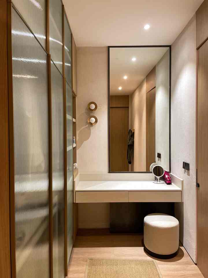 Natural color and white narrow entrance featuring large mirror, vanity, and white stool with a minimalist atmosphere