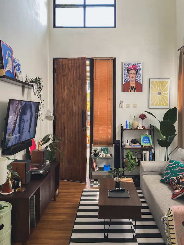 Warm living room with wood-tone floor and furniture, featuring a gray sofa and central coffee table