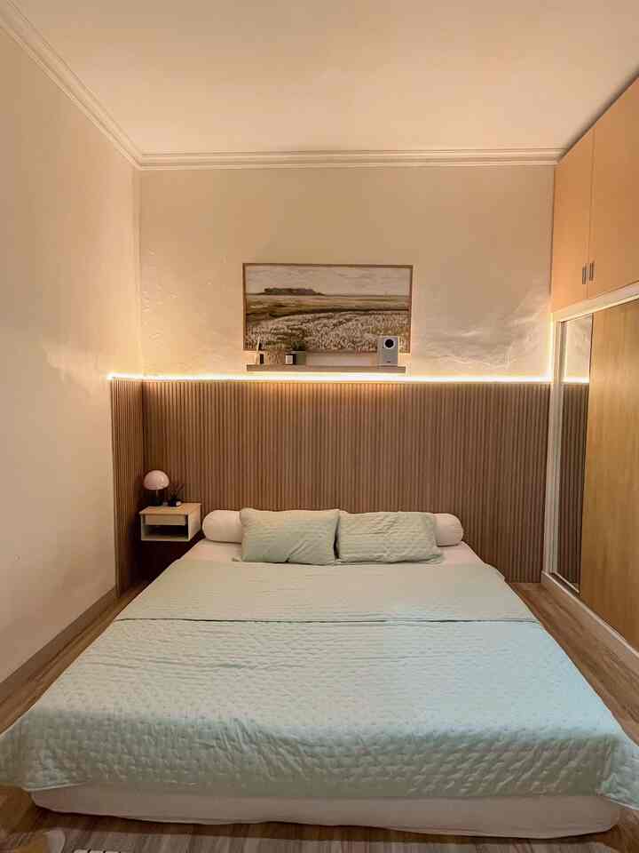 Natural Japandi bedroom with light brown wood tone wall paneling and a floating nightstand