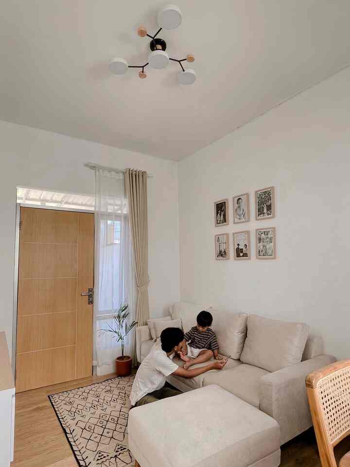 Ruang tamu atau keluarga dengan desain minimalis dan nuansa hangat, dan pastinya membuat rumah nyaman dan Aesthetic🏡

- Warna Dominan: Dinding berwarna putih yang memberi kesan bersih dan lapang

- Perabotan : Terdapat sofa berwarna krem muda dengan ottoman di depannya, memberikan nuansa yang lembut dan nyaman.

- Hiasan Dinding : Terdapat enam bingkai foto berwarna cokelat muda yang tergantung rapi di dinding, memberikan elemen personal ke ruangan.

- Pencahayaan : Lampu gantung di langit-langit memiliki desain modern dengan beberapa lampu berbentuk bulat.

- Tanaman Hias : Ada satu pot tanaman kecil di samping sofa, menambah kesan alami di ruangan.

- Lantai : Lantai berbahan kayu berwarna cokelat muda yang menambah kehangatan ruangan, ditambah dengan karpet berpola geometris di area dekat pintu.

ruangan ini terasa nyaman, dan terlihat rapi dengan kombinasi warna-warna netral.

#WarnaCatRumah
#LivingRoomEstetik
#LivingRoomMinimalis
#Minimalis
#MaterialEstetik
