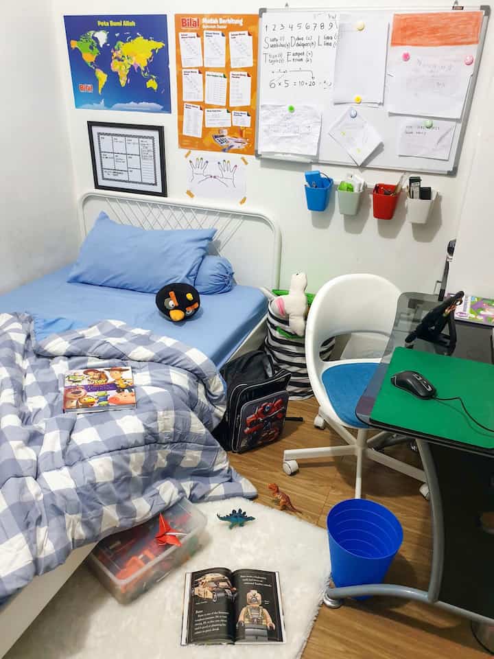 White and blue toned kids' room featuring a child's bed, desk, toys, and study materials arranged comfortably