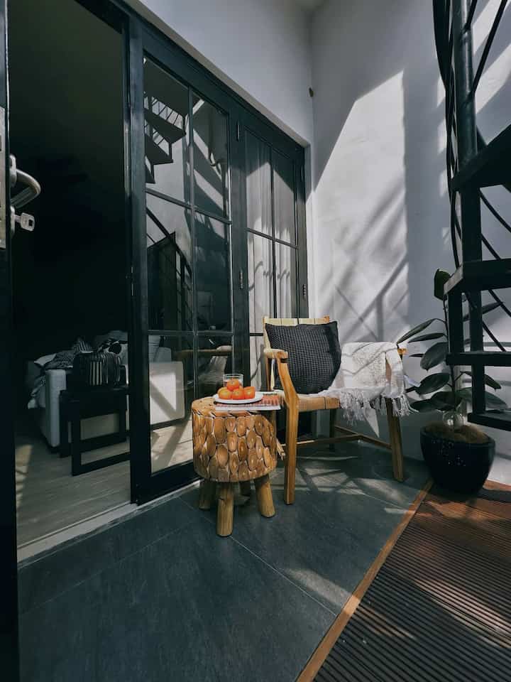 Sudut bawah tangga ini biasanya aku gunakan untuk berjemur di pagi hari. Suara burung dan alam membuatku merasa nyaman sembari membaca atau minum kopi.

Penggunaan material di area outdoor ini beragam:
Warna cat putih, Lantai keramik warna abu, Pintu kaca untuk cahaya masuk ke family room, Kayu bengkirai di dekat taman untuk kesan nyaman dan natural.

Tips membuat area atau ruangan menjadi fungsional:
Pilih material yang tepat untuk setiap area, Gunakan warna yang cerah untuk kesan luas dan terang, Tambahkan elemen alami seperti kayu dan tanaman, Pastikan pencahayaan alami maksimal dengan pintu atau jendela kaca, Dekorasi dengan furnitur yang nyaman dan fungsional.

#catdindingputih #lantaikeramikoutdoor #lantaikayubengkirai #pintukacabesiholo
#OutdoorLiving #HomeDecor #CozyCorner #FunctionalSpaces #InteriorDesign #NaturalElements #MorningSun #ReadingNook #CoffeeTime #HomeInspiration #materialestetik