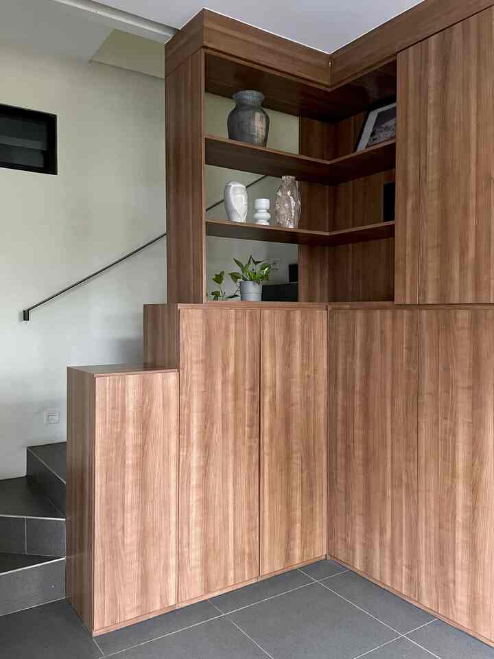 Minimal entrance space featuring wood tone cabinets and dark gray stairs