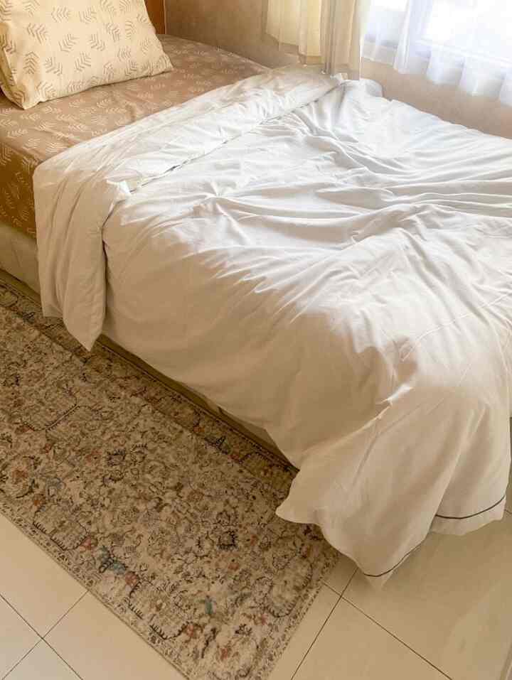 Beige and white toned bedroom featuring a bed with Bohemian style rug, creating a calm atmosphere