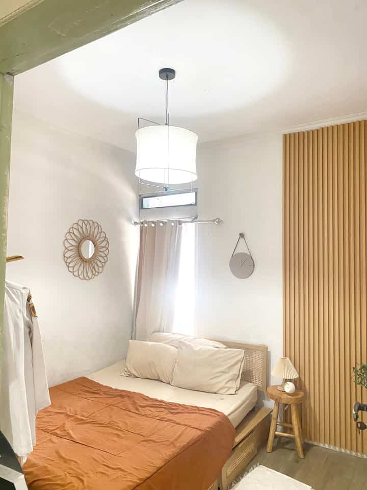 Square 2.8m bedroom in white, beige, and wood tones featuring a bed, nightstand, and rattan headboard with a warm modern feel