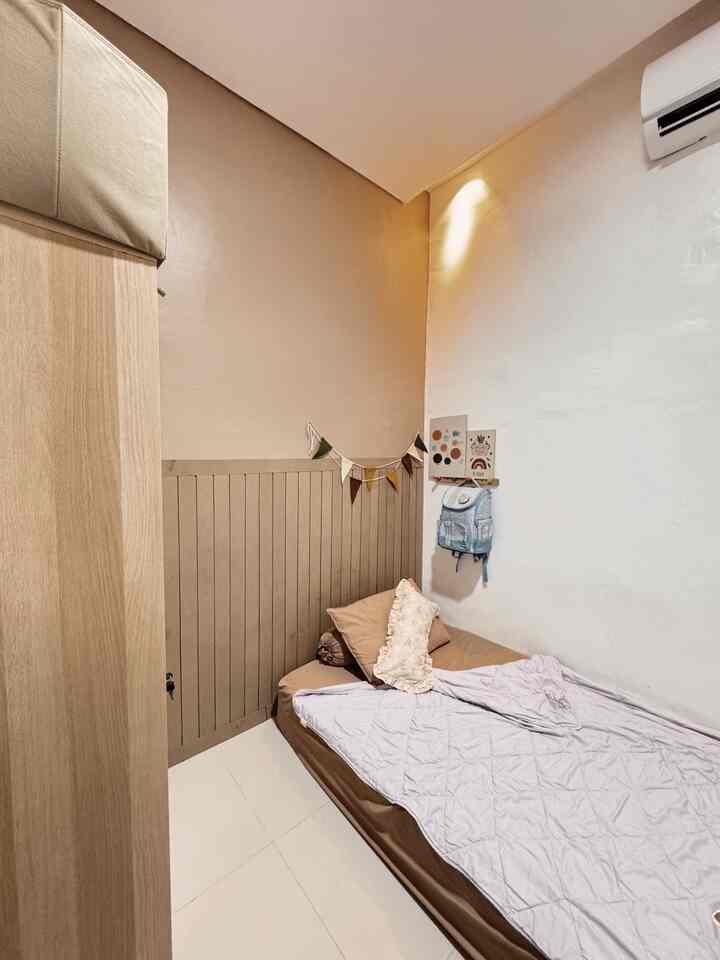 Cozy kids' bedroom in beige and brown tones, featuring a child's bed and wall decorations in a compact space