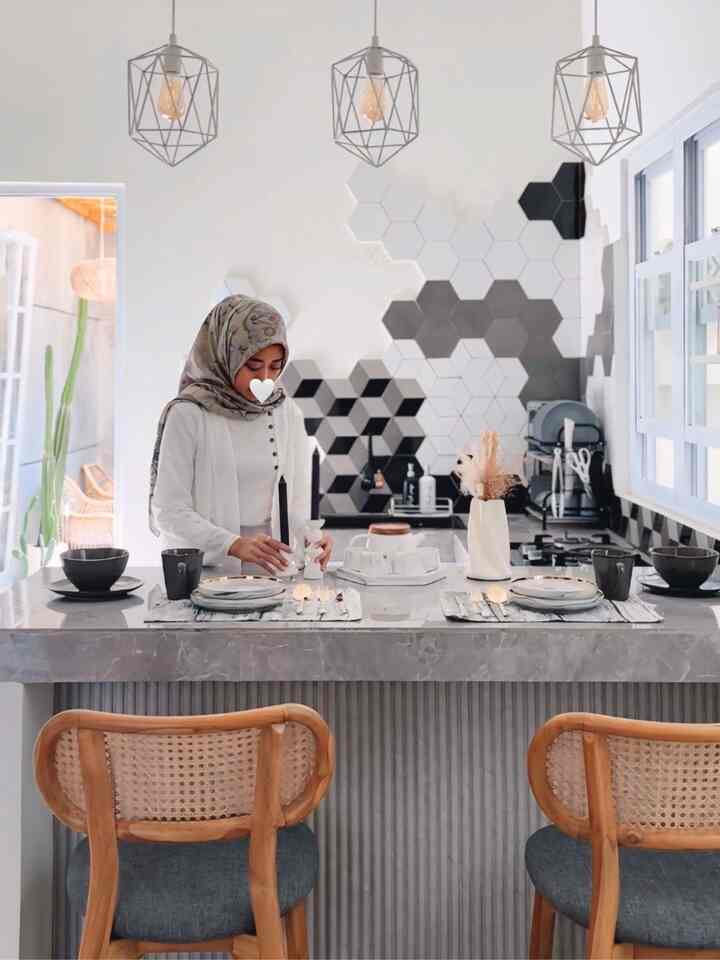 Modern kitchen dining room in gray with gold accents, featuring a kitchen island and dining chairs arranged for two in a cozy setting