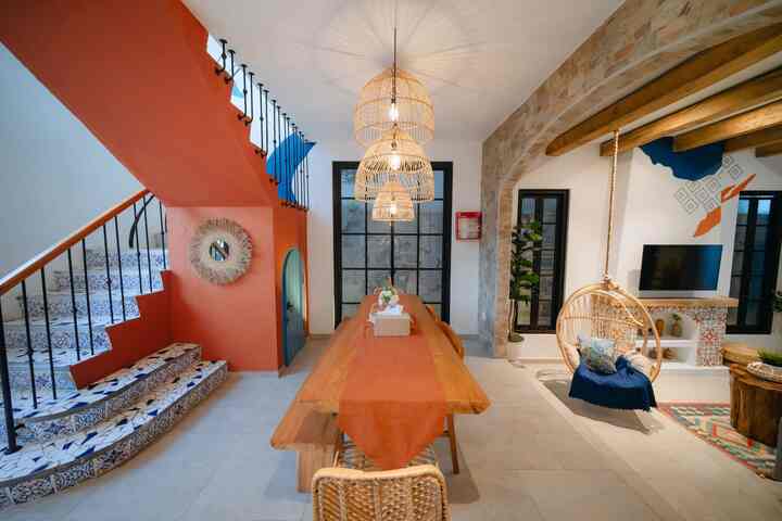 Warm wood-tone natural modern living and dining area featuring arch walls and rattan lighting creating a cozy atmosphere