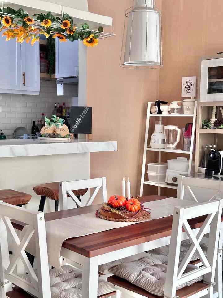 White and brown toned dining room featuring a wooden dining table with table runner, pendant light, and decorated centerpiece