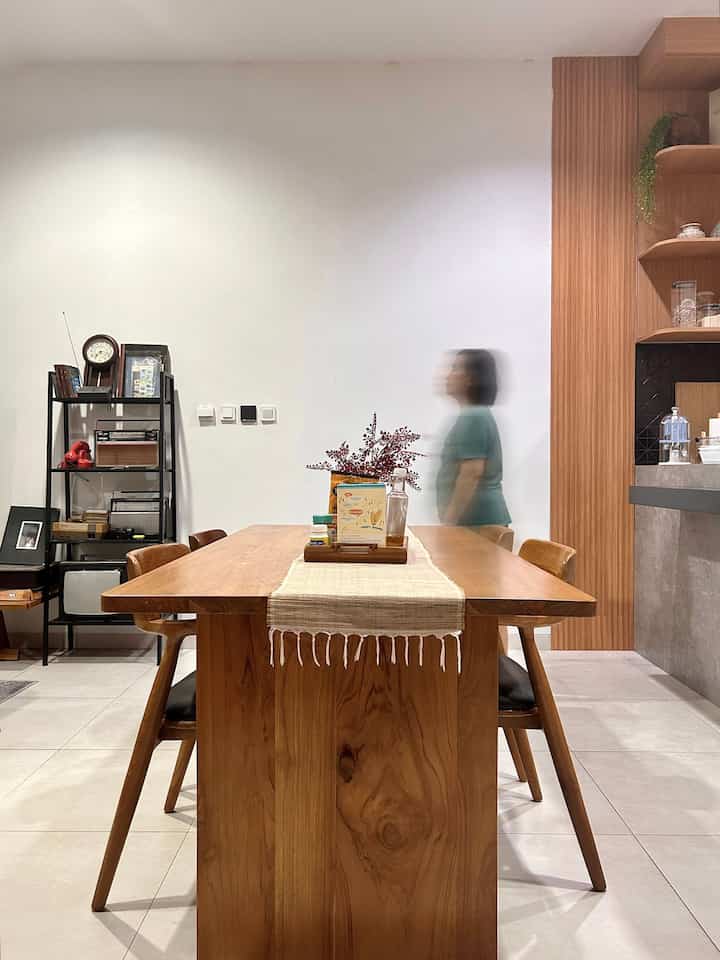 Ruang makan dengan konsep open plan sengaja dibuat agar lebih leluasa saat ada banyak keluarga kumpul, bisa duduk di ruang keluarga maupun meja makan. Selain itu, kita juga suka makan sambil nonton tv dan rumah jadi terasa lega. 

Material dipilih dari kayu jati natural dengan model meja dan kursi japandi yang sesuai dengan tema rumah kami. 
Untuk alas duduk tetap menggunakan busa agar nyaman. Sudut meja pun tumpul sehingga lebih aman untuk anak-anak.

#MejaMakanJapandi #MejaMakanKayuJati #InspirasiRuangMakan #DiningRoomStyling #OpenPlanLayout #DiningRoom #KitchenDesign #RumahTropis