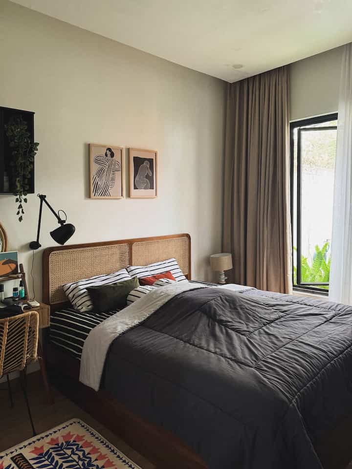 A calm natural wood tone and gray accented bedroom featuring a wooden bed and beige curtains creating a cozy atmosphere