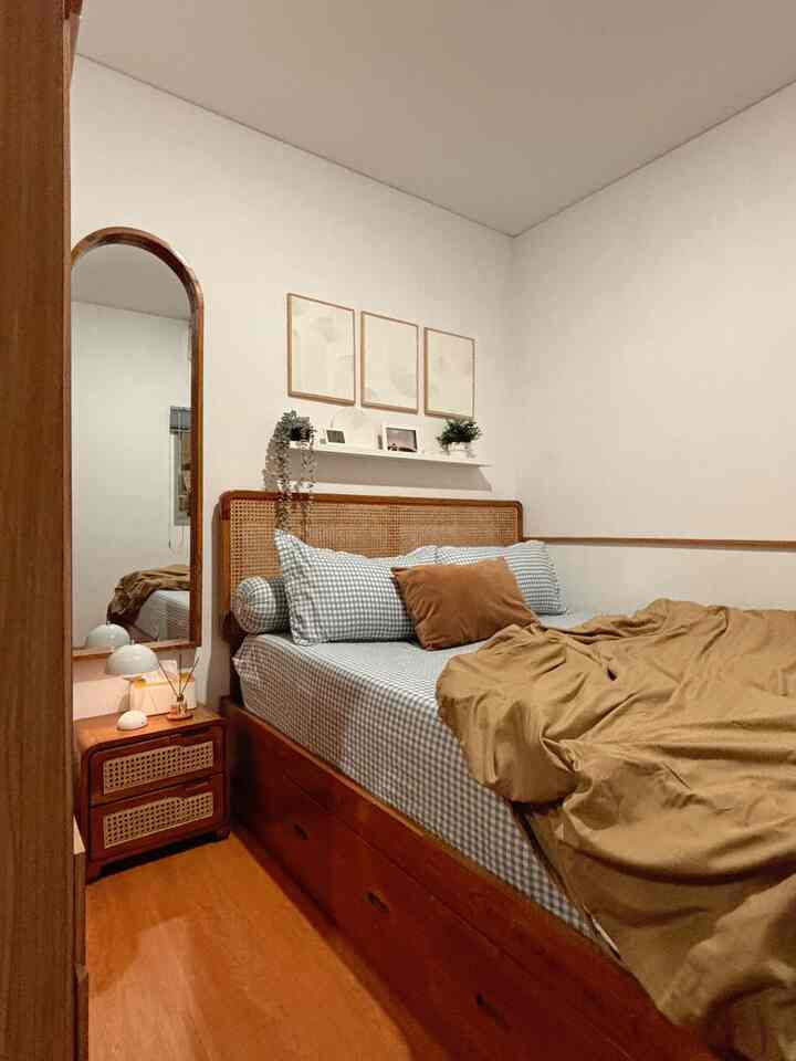 Bedroom with wood tones and white walls, featuring a storage bed and nightstand in a cozy compact space