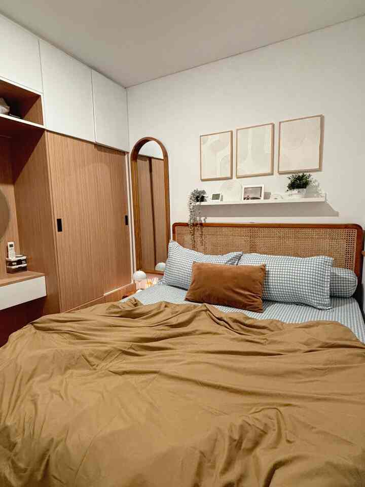 Natural toned bedroom with white walls and brown wood storage, featuring neat duvet cover and comfortable bed in a cozy setting
