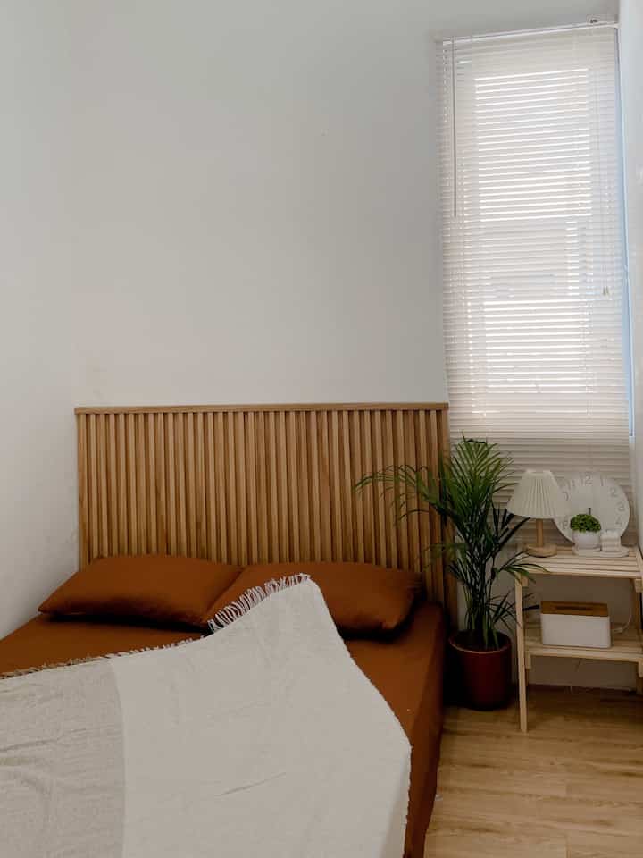 Pemilihan dekorasi seperti ini didasari oleh beberapa alasan:

1. Gaya Minimalis: Dekorasi ini mencerminkan gaya minimalis yang mengutamakan kebersihan visual, ruang yang lapang, dan furnitur yang sederhana namun fungsional. Gaya ini cocok untuk menciptakan ketenangan dan mengurangi distraksi di dalam ruangan.
  
2. Kesan Alami : Penggunaan material kayu dan tanaman hijau menciptakan nuansa alami yang menenangkan. Kayu memberikan kehangatan, sedangkan tanaman membawa kesegaran ke dalam ruang.

3. Palet Warna Netral : Warna-warna netral seperti putih, cokelat, dan krem sering digunakan untuk menciptakan suasana yang menenangkan dan nyaman, sekaligus membuat ruangan terasa lebih luas dan terang.

4. Fungsi dan Estetika : Dekorasi ini tampaknya menyeimbangkan antara fungsi dan estetika. Setiap elemen, seperti meja samping, lampu, dan tanaman, tidak hanya memiliki fungsi praktis tetapi juga menambah estetika visual ruangan.

5. Kesederhanaan dan Kenyamanan : Penataan seperti ini sering dipilih oleh orang yang mencari suasana sederhana namun nyaman di kamar tidur, tanpa terlalu banyak dekorasi yang bisa membuat ruang terasa sesak atau berantakan.

#BedroomStyling
#MakeOverKamarTidur
#CatKamarMinimalis
#Vinyl
#KasurBusa
#Wallpanel
#RakSusunKamar
#TiraiPutih
#Cat
#GunnemorCream
#LampuTidur