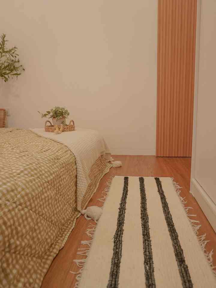 Natural color and wood tone 6-tatami bedroom featuring beige checkered bedding and striped rug in a cozy atmosphere