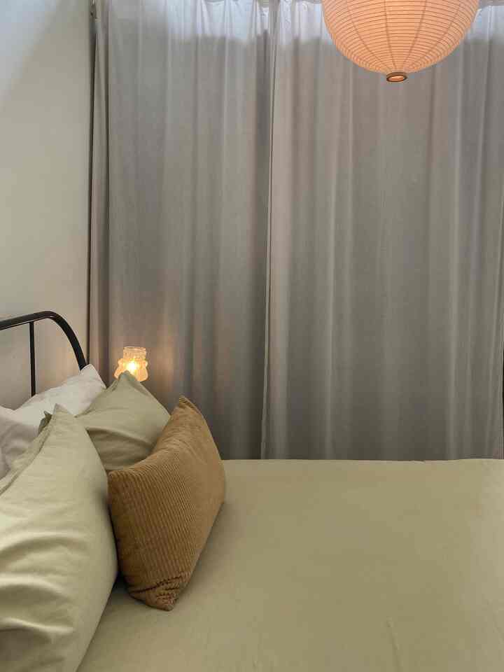 Cozy bedroom space with beige curtains and light brown cushions