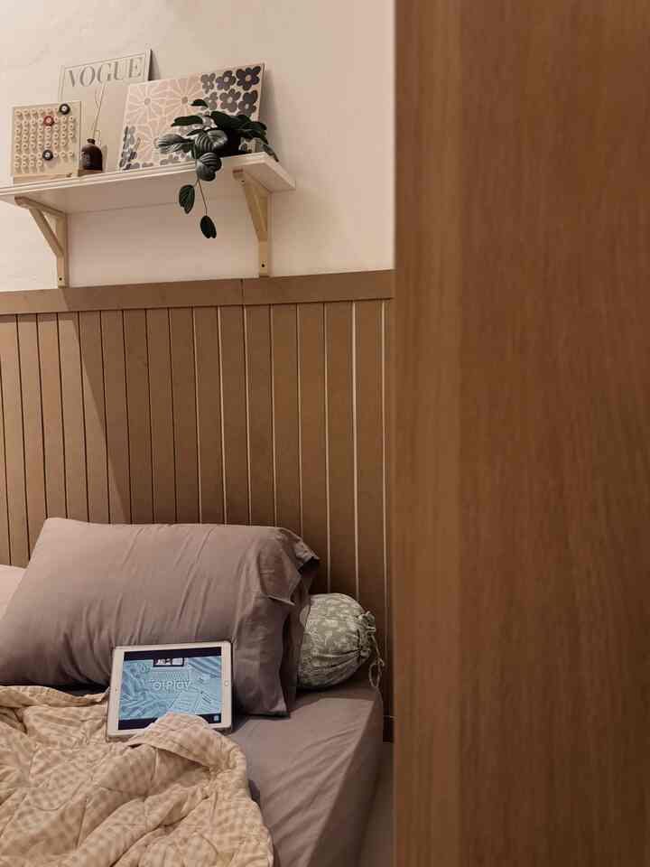 Natural color and wood tone small bedroom featuring simple wall battens and bedding with warm cozy atmosphere