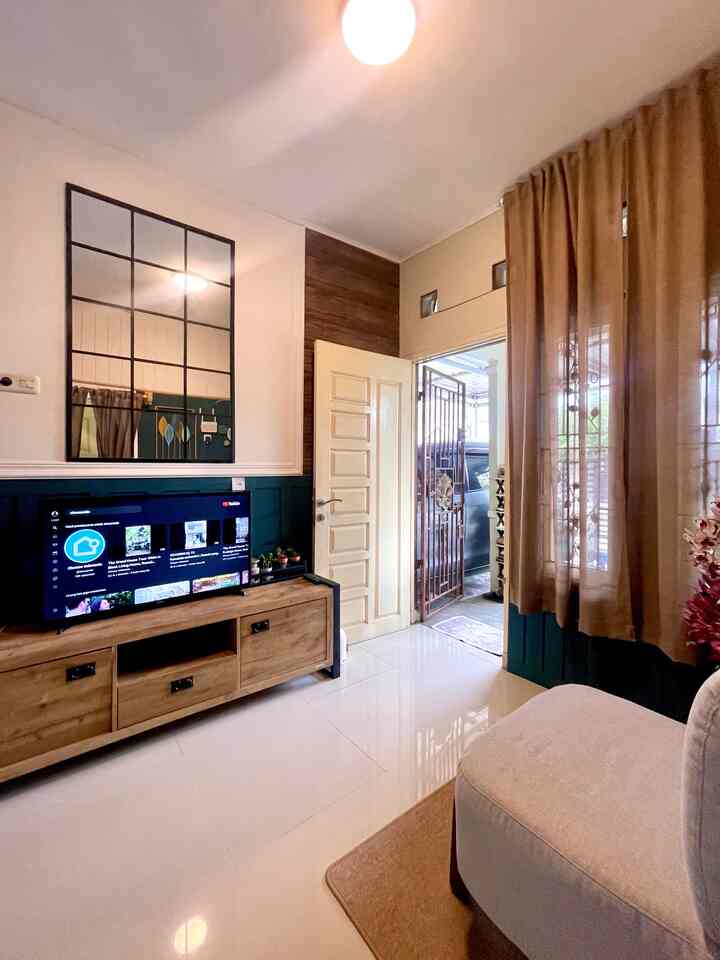 A cozy living room featuring beige and wood tones, with a beige sofa and wooden TV stand arranged harmoniously