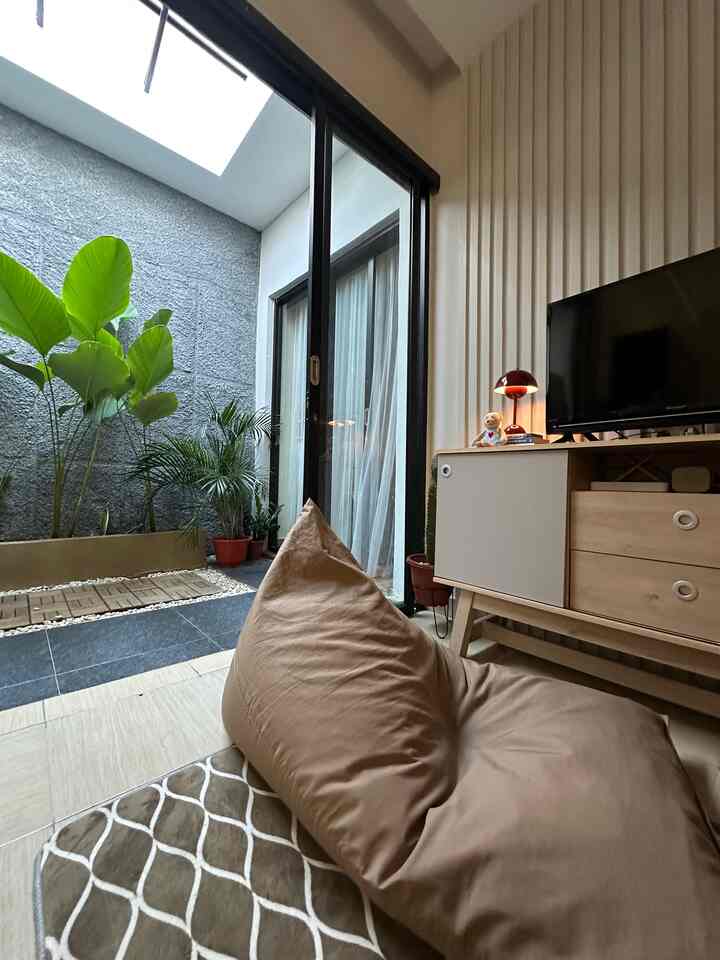 Natural-toned living room featuring a bean bag and plants with a cozy, modern atmosphere