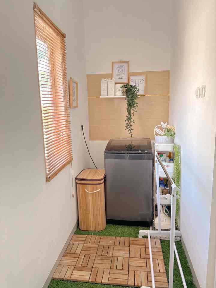 Bright white and beige tone long, narrow laundry room featuring wood-tone flooring and decorative plants with a functional atmosphere