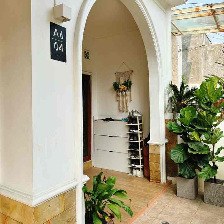 White and natural toned entrance space featuring a shoe cabinet and various plants with cozy Scandinavian style interior