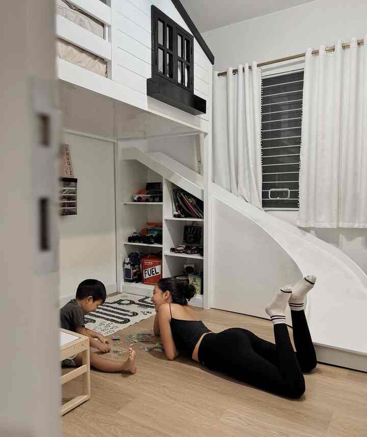 White and brown toned kids' room featuring a loft bed and play area with a cozy atmosphere