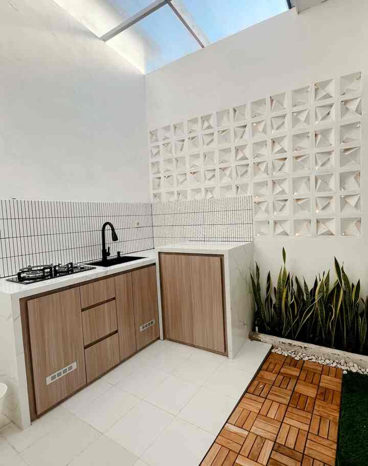 Dapur minimalis dengan sentuhan modern yang menawan. Elemen natural dan sederhana memberi kesan ruangan yang lapang dan terang.

Beberapa item dekoratif dan furniture yang digunakan di dapur ini:

1. Kabinet kayu dengan finishing natural – Menambah nuansa hangat dan alami pada dapur.

2. Backsplash keramik bergaris hitam-putih – Desain garis vertikal memberikan kesan lebih tinggi pada ruangan.

3. Keran hitam matte – Memberi sentuhan modern dan elegan pada area wastafel.

4. Batu alam putih – Diletakkan di bawah tanaman, memberikan aksen alam yang menyegarkan.

5. Tanaman sansevieria – Berfungsi sebagai dekorasi hijau yang tidak hanya mempercantik, tetapi juga membersihkan udara.

6. Lantai kayu berpola – Area dengan lantai kayu ini menambah kehangatan dan kontras yang indah di dapur minimalis ini.

7. Ventilasi dekoratif beton berlubang – Memberikan cahaya alami serta sirkulasi udara yang baik.

Ruangan ini menciptakan perpaduan harmoni antara elemen alami.

#MakeOverDapur
#StylingDapur
#Kitchenset
#solarflat
#Lantaikayu
#HplTaco
#KeramikDingdingMozaik
#Dapurminimalis