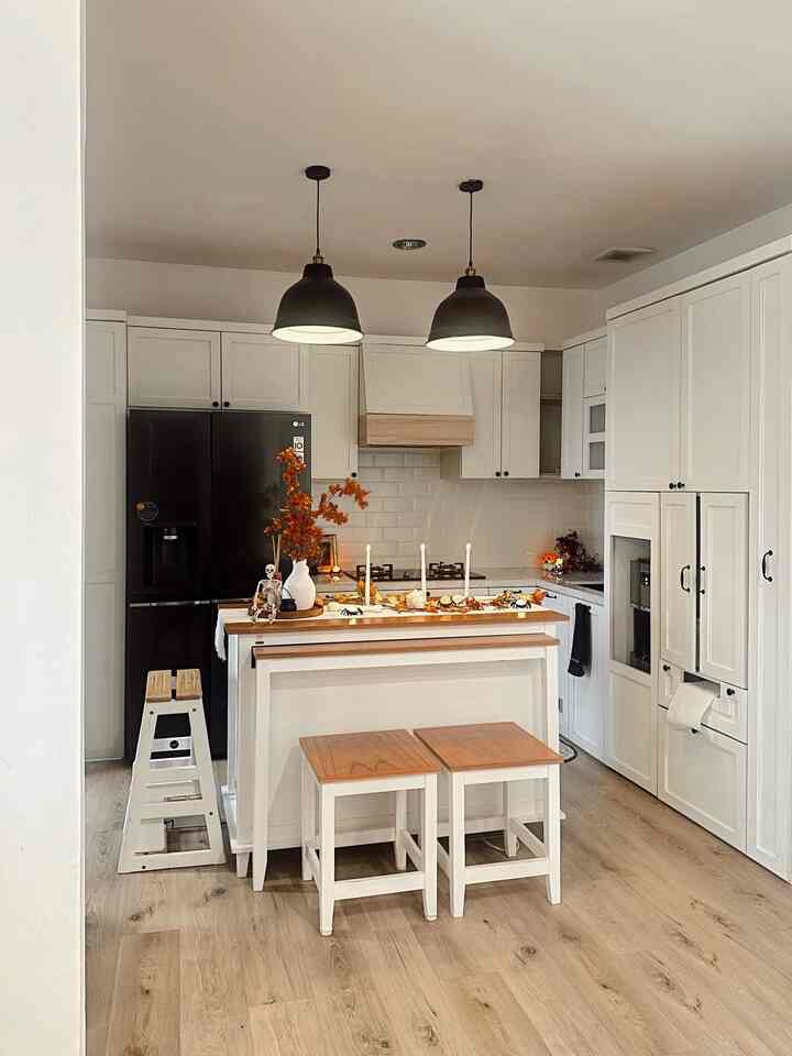 White and natural-toned kitchen featuring a kitchen island and pendant lights with warm and stylish atmosphere