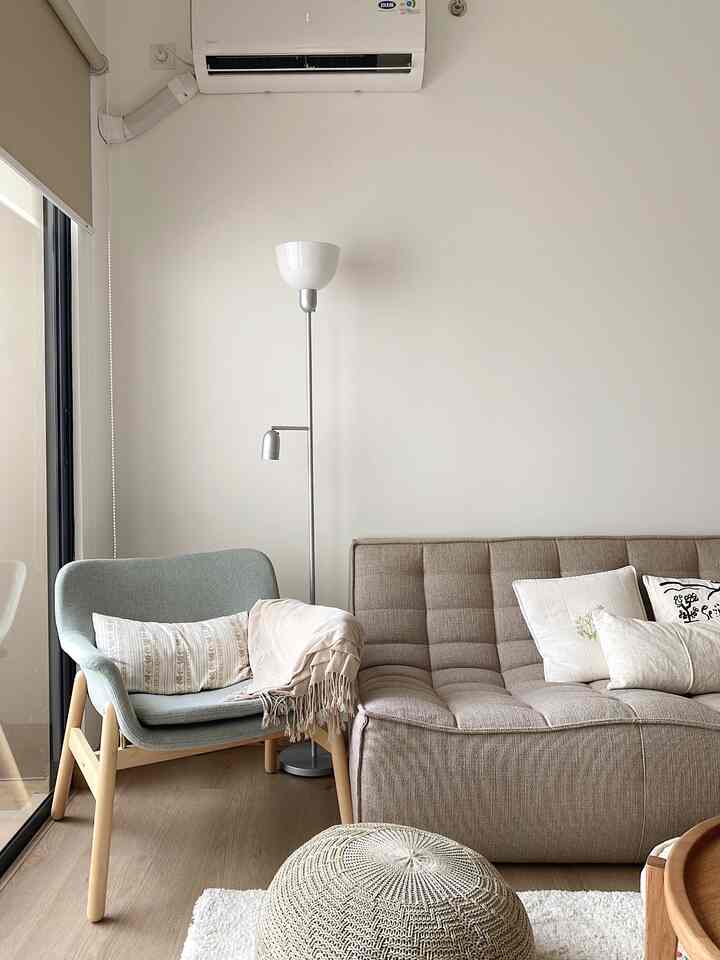 Living room corner with beige and natural tones featuring a blue armchair and floor lamp creating a cozy atmosphere