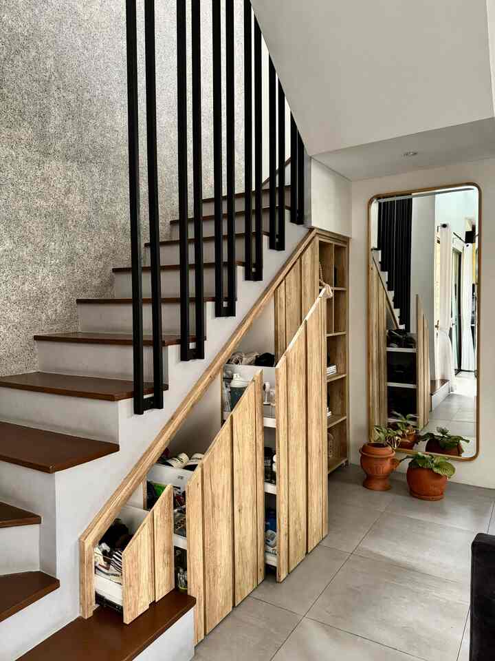 Clean entrance space featuring brown and white stairs with built-in storage drawers underneath