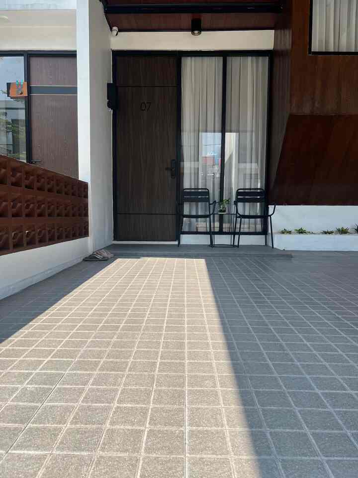 White and brown tone balcony space featuring two black outdoor chairs and a small table creating a clean outdoor relaxation area