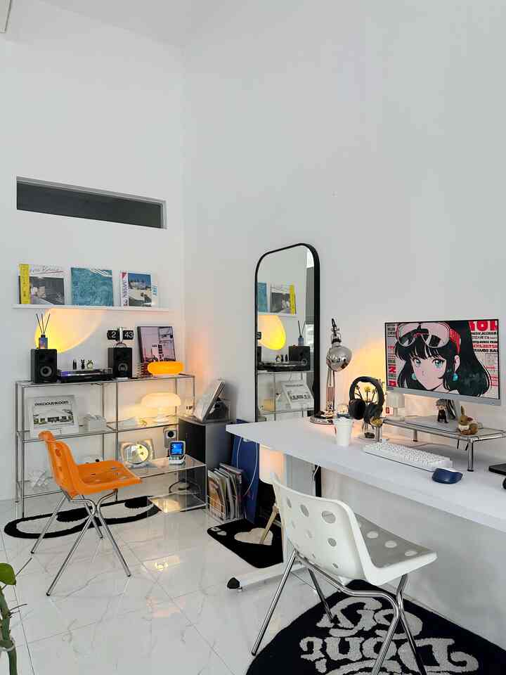 Modern home office space with white walls and floors, featuring a transparent corner shelf and an orange chair