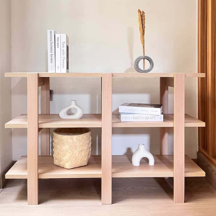 Beige wall and wood tone shelf featuring natural objet decor in a minimalist setup