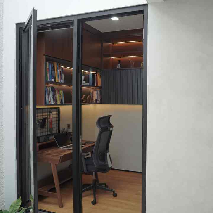A compact home office blending wood tones and white, featuring a desk and office chair in a modern workspace
