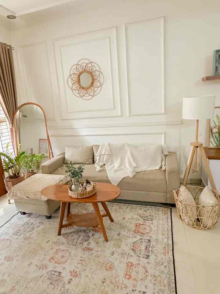 Warm beige and wood tone living room featuring sofa, coffee table, and round rattan mirror in a natural style interior