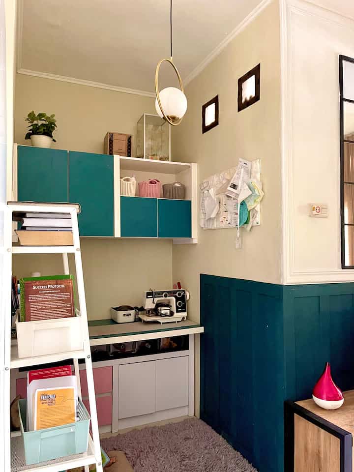 Compact multipurpose room in white and navy tones featuring pendant lighting and organized storage cabinets with a neat atmosphere