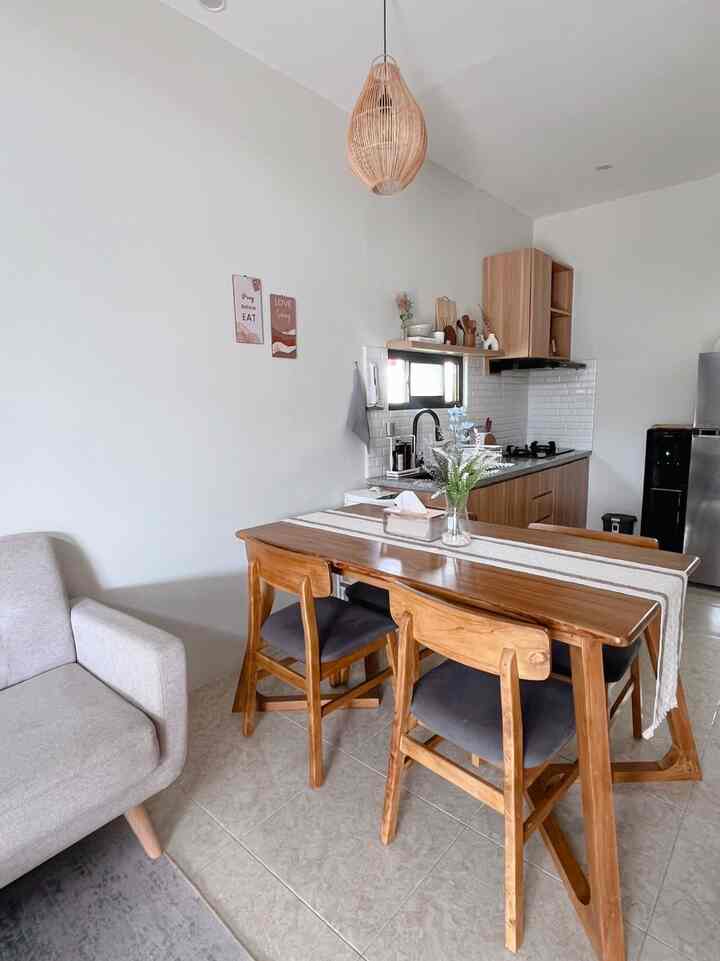 Natural color dining room featuring wood tone dining table and chairs with cozy Korean interior style