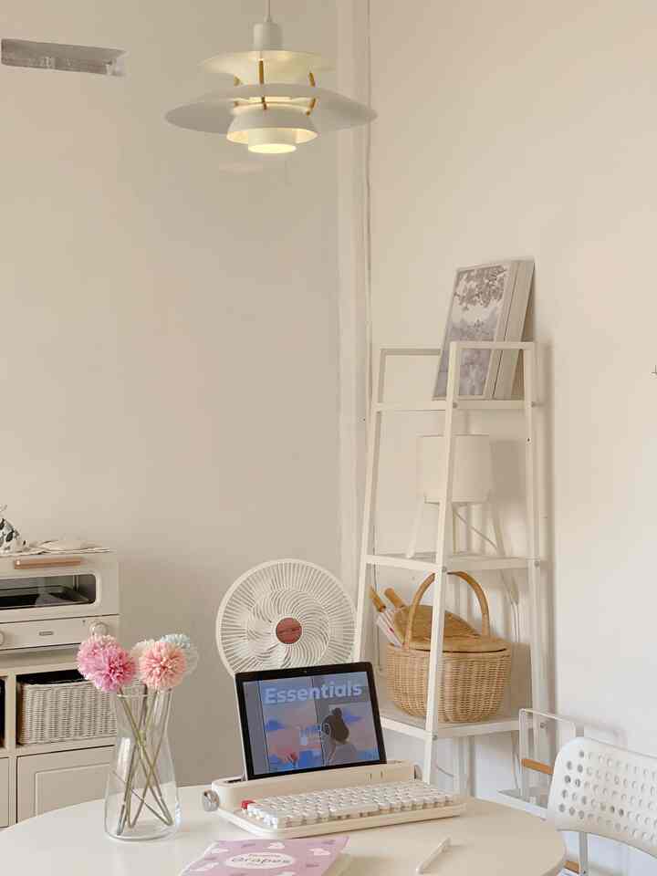 White-toned multifunctional room featuring round table, shelf, and pendant light with simple clean interior