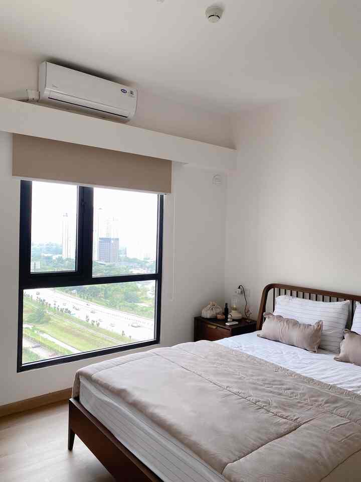 White and brown toned bedroom featuring a large window, bed, and nightstand in a clean space