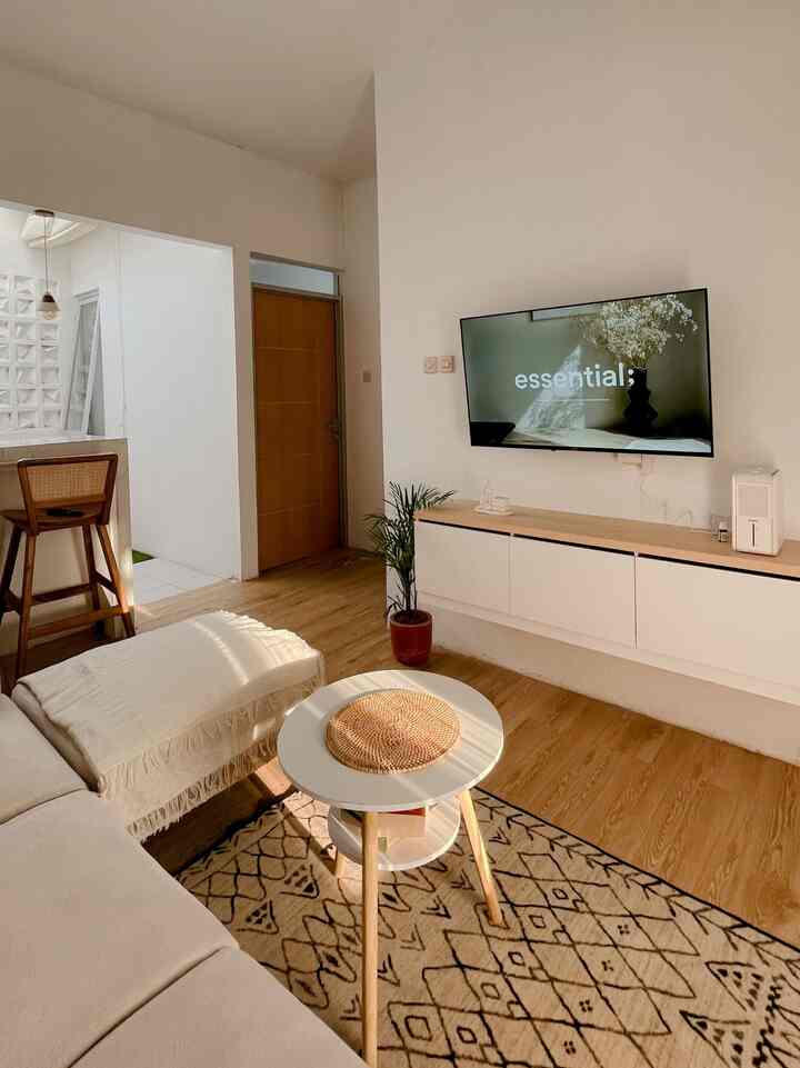 Ruang keluarga sekaligus tami ini memiliki suasana yang tenang dan minimalis dengan nuansa yang cozy.

- Palet Warna: Ruangan ini memiliki skema warna hangat dan netral, dengan sentuhan warna beige, putih, dan kayu alami yang memberikan kesan rileks.

- Furnitur: Sofa berbentuk sectional dengan bantal yang empuk dan meja bundar kecil menambah suasana nyaman. Penggunaan tekstur alami, seperti anyaman pada meja, memberikan sentuhan rustic yang halus.

- Dekorasi: Dinding galeri dengan bingkai foto memberikan sentuhan personal dan homey, sementara tanaman dalam pot menambah kesegaran alami ke dalam ruangan.

- Pencahayaan: Lampu gantung modern dengan desain minimalis ini menyatu sempurna dengan kesederhanaan keseluruhan ruangan.

- Tata Letak: Penataan yang fungsional dan mengundang, dengan area terbuka yang memberikan kesan lapang pada ruangan.

Secara keseluruhan, ini adalah ruang yang tertata dengan indah dan terasa nyaman!🏡

#RumahMinimalis
#InspirasiRumah
#LivingRoom
#HomeDecor
#SofaMinimalis
#Lemaritv
#RuangNonton
#CatRumah
#VinylKayu
#RumahMungil
