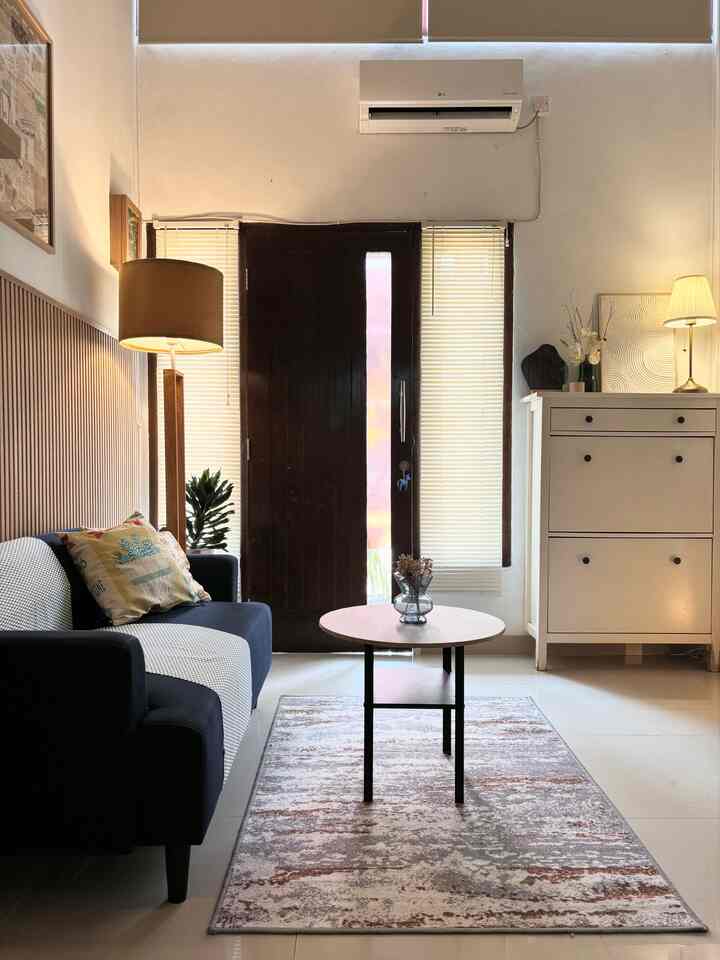 White and sky blue toned living room featuring a two-seater sofa and coffee table with a cozy modern atmosphere