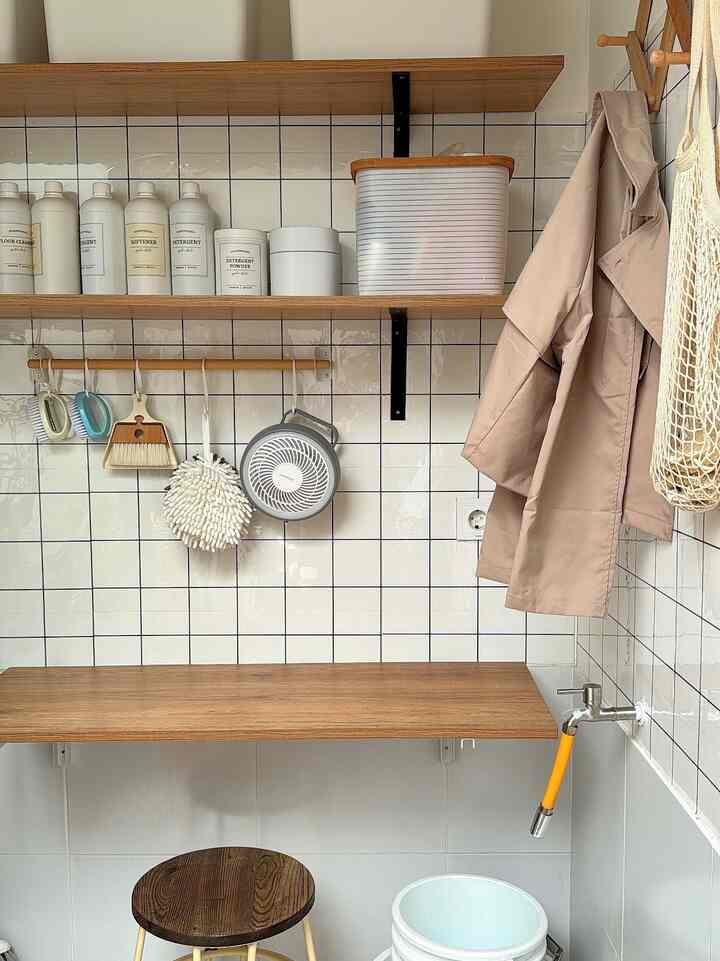 Natural-toned organized storage area featuring wooden shelves and hanging storage items in a practical corner space