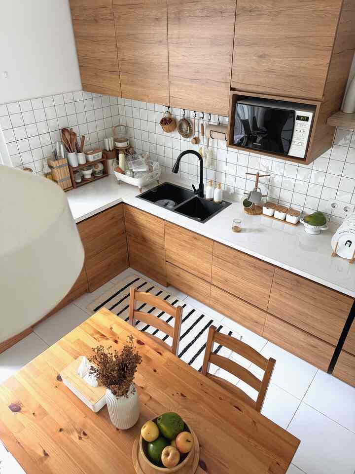 Minimal kitchen with natural brown wood tones and white tiled backsplash featuring wooden dining table and chairs