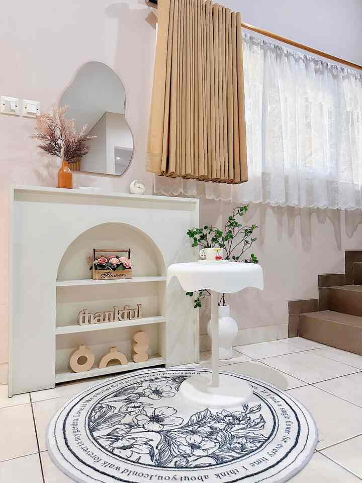 Brown and white toned living room featuring a curvy mirror, small table, and storage rack with a clean minimalistic interior